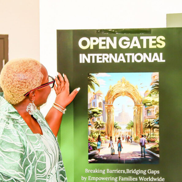 Woman looking at a large poster that says "Open Gates International"